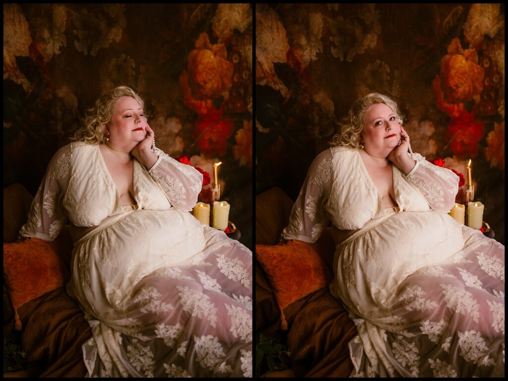 A person with curly hair wearing a white lace dress poses thoughtfully on a couch. In this boudoir-inspired setting, they rest their chin on one hand, surrounded by vibrant floral wallpaper and lit candles, creating a warm and reflective atmosphere that echoes a Renaissance dream.