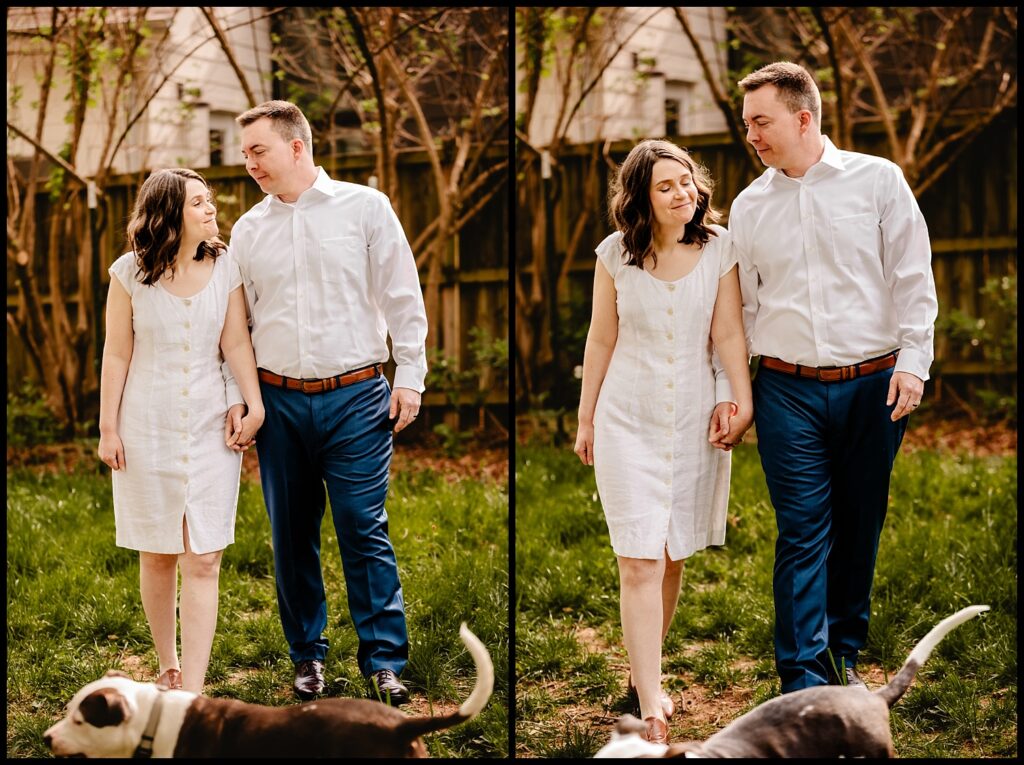 Jess and Chris, dressed in white and blue, hold hands and walk outside on grass, smiling at each other. A dog with a white-tipped tail is partially visible at the bottom, with trees and a wooden fence in the background.