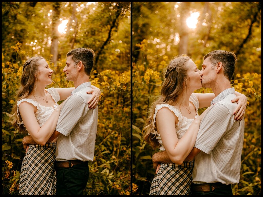 A couple stands in a sunlit forest during their engagement session, embracing with smiles in the first photo and sharing a kiss in the second, surrounded by tall yellow wildflowers and lush greenery at golden hour.