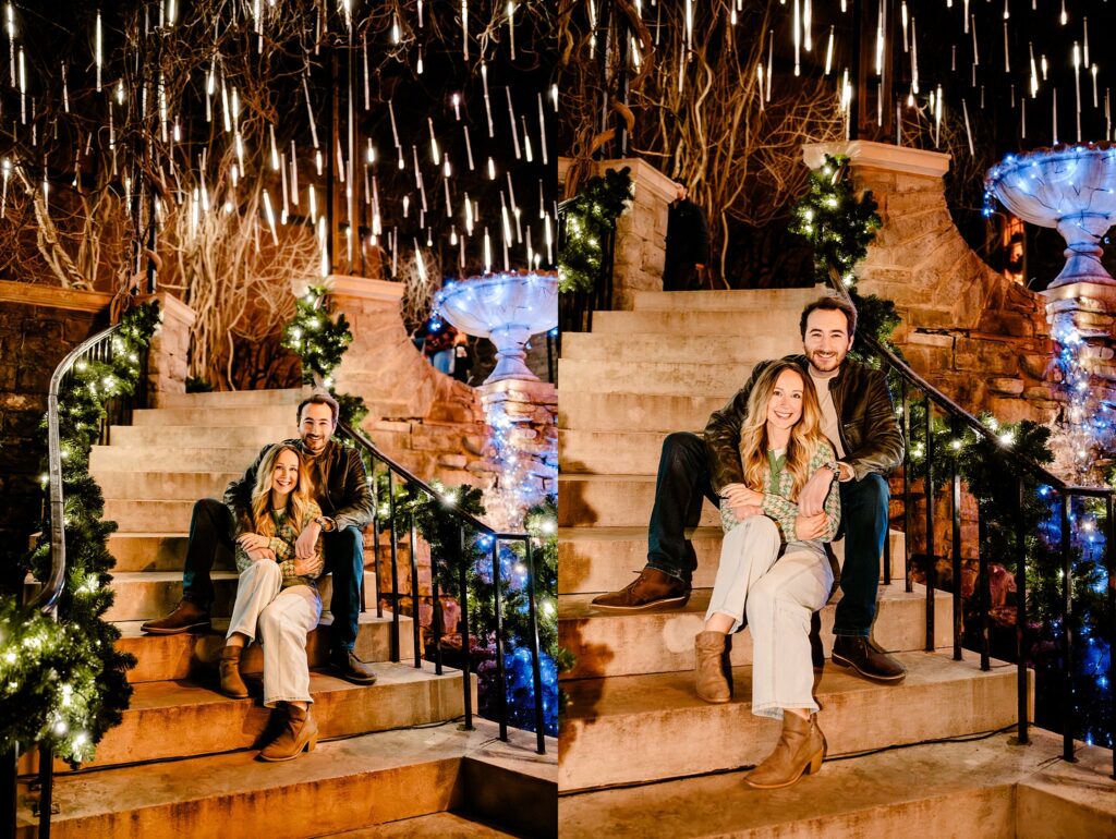 A couple sits and smiles on outdoor steps at Cheekwood, decorated with holiday lights, garlands, and a glowing fountain—surrounded by hanging, illuminated lights at night—perfect for a Nashville Proposal Photographer capturing your Surprise Proposal.