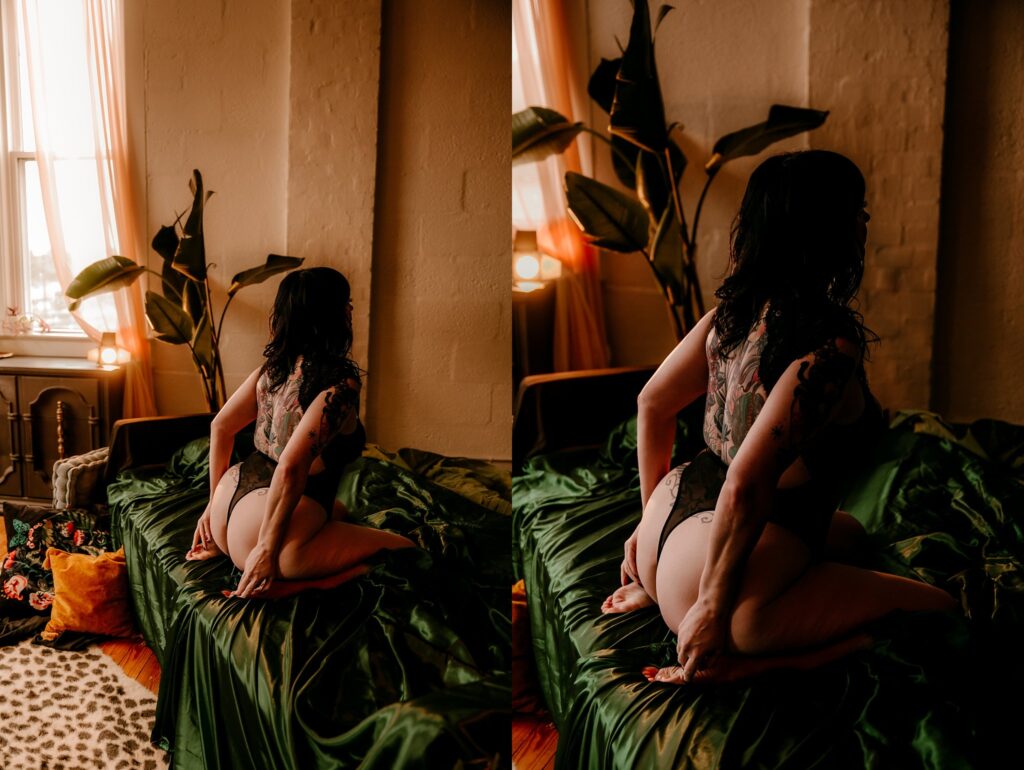 A woman with dark hair and tattoos kneels on a bed draped in green satin sheets in a warmly lit room with large plants and a window, captured in two similar side-by-side views from behind—perfect for bold boudoir photography lovers.