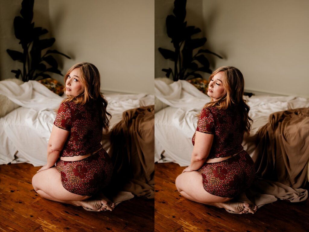 A woman with long hair wearing a matching red patterned crop top and shorts kneels barefoot on a wooden floor beside a bed with rumpled sheets and tan blanket, striking bridal boudoir poses as she looks over her shoulder in two side-by-side photos.