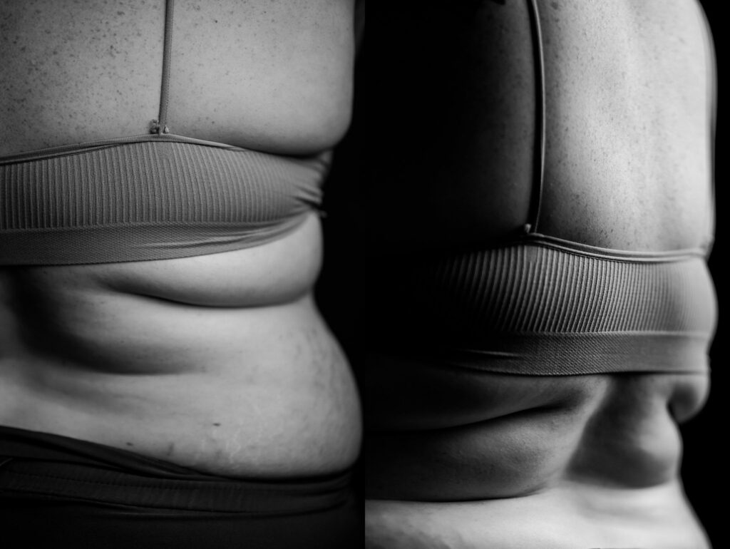Black and white close-up photo by a Nashville creative portrait photographer, showing the back and side of a person in a ribbed sports bra, with natural skin folds and texture highlighted.